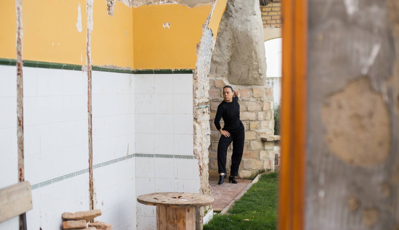 Rocio Molina presses a hand against a stone door jamb